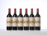 four bottles of red wine lined up in a row