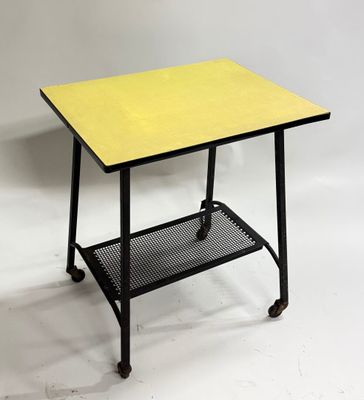 une petite table avec un plateau jaune et des pieds noirs
