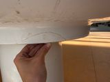 a hand that is holding a piece of paper over a toilet