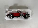 a red toy car in a plastic container on a white surface