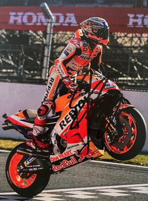 un homme qui roule à moto sur une piste, coiffé d'un casque
