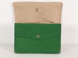 un gros plan sur un sac à main vert contenant une enveloppe beige
