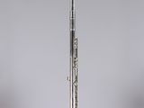 a silver flute on a clear stand against a gray background