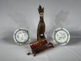 trois assiettes et une figurine représentant un homme assis sur un banc