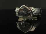 an image of a black and silver watch on a black surface