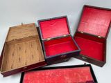 three open wooden boxes sitting on top of each other on a white surface