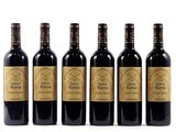 four bottles of wine are lined up on a white surface