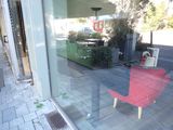 reflection of a red chair in a glass window of a restaurant