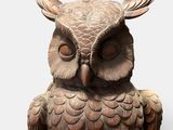 an owl statue that is sitting on a white surface
