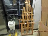 a stack of wooden chairs next to a refrigerator in a room