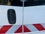 une camionnette blanche avec des bandes rouges et blanches sur le côté