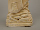 a statue of a man holding a book on a table