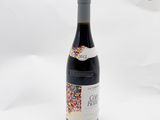 La bouteille de vin est ornée de paillettes sur fond blanc.