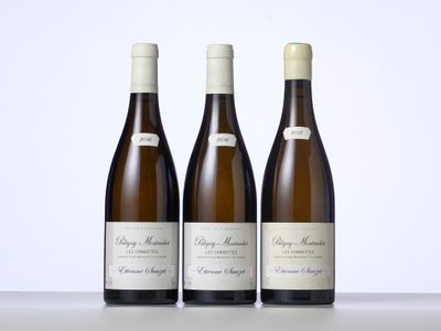 trois bouteilles de vin sont alignées sur une table