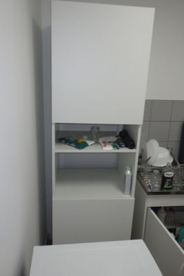 une petite cuisine équipée d'un évier et d'un placard