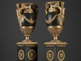 deux vases noirs et dorés posés l'un sur l'autre