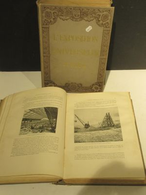 un livre ouvert posé sur une table à côté d'une boîte