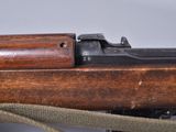 an old wooden rifle with a sling attached to it ' s side