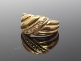 an image of a gold ring with diamonds on a reflective surface