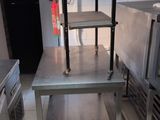 une table en acier inoxydable avec une étagère, dans une cuisine