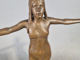 a bronze statue of a woman holding her arms out