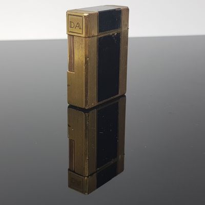 a gold lighter sitting on top of a black table