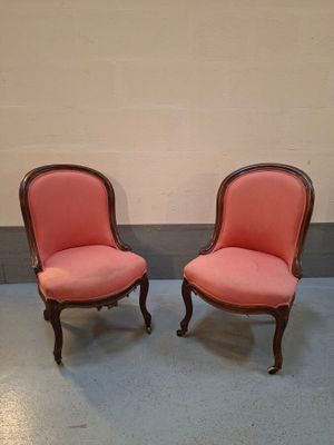 pair of pink upholstered chairs in the corner of a room