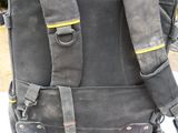 a black backpack with tools on a table outside