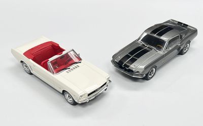 deux voitures jouets assises l'une à côté de l'autre sur une surface blanche