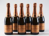 six bottles of champagne lined up in a row