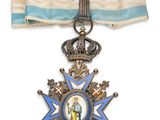 un gros plan d'une médaille sur un ruban, surmontée d'une couronne
