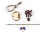 three pieces of jewelry including a broochle, a broochle, and a pair of scissors