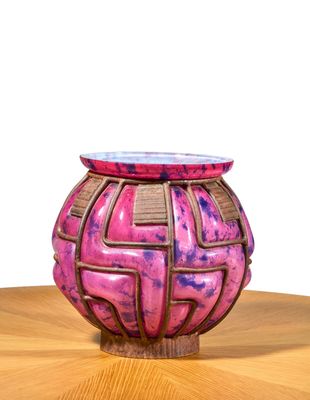 a pink vase sitting on top of a wooden table