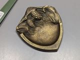 a gold plate with a dragon on it next to a pair of scissors