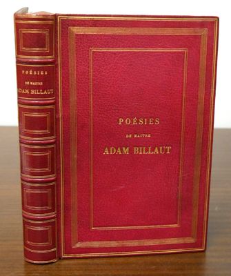 a red book sitting on top of a wooden table next to a white wall
