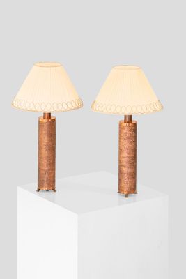 two lamps on top of a white cube with a white shade