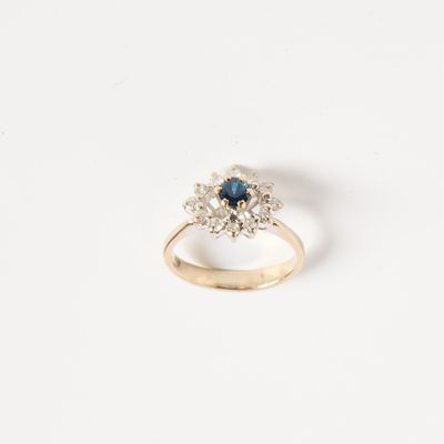 un gros plan d'une bague en or sertie d'un saphir bleu et de diamants blancs