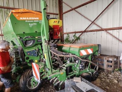 un homme qui se tient à côté d'un tracteur vert