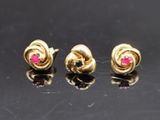 trois paires de boucles d'oreilles en or et rubis sur un fond noir