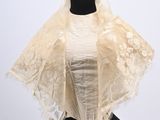 a close up of a mannequin wearing a white shawl on a mannequin
