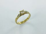 a close up of a gold ring with a diamond on it