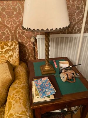 a small table with a lamp on top of it next to a couch