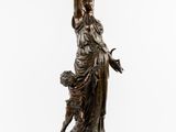 an antique bronze statue of a woman holding a basket of flowers