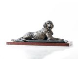 statue d'un chien couché sur un socle en bois, sur fond blanc