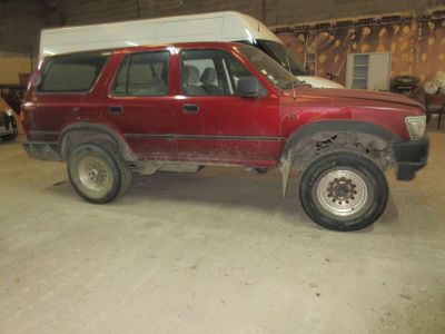 un camion rouge avec une caravane sur le toit, dans un garage