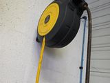 un tuyau fixé au mur, muni d'une poignée jaune