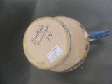 underside view of a vase with writing on it on a table
