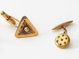 three pairs of gold cufflinks and a pair of earrings on a white surface