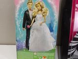 two barbie dolls are sitting on a table next to each other