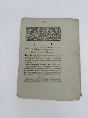 un vieux livre posé sur une table blanche à côté d'un mur blanc
